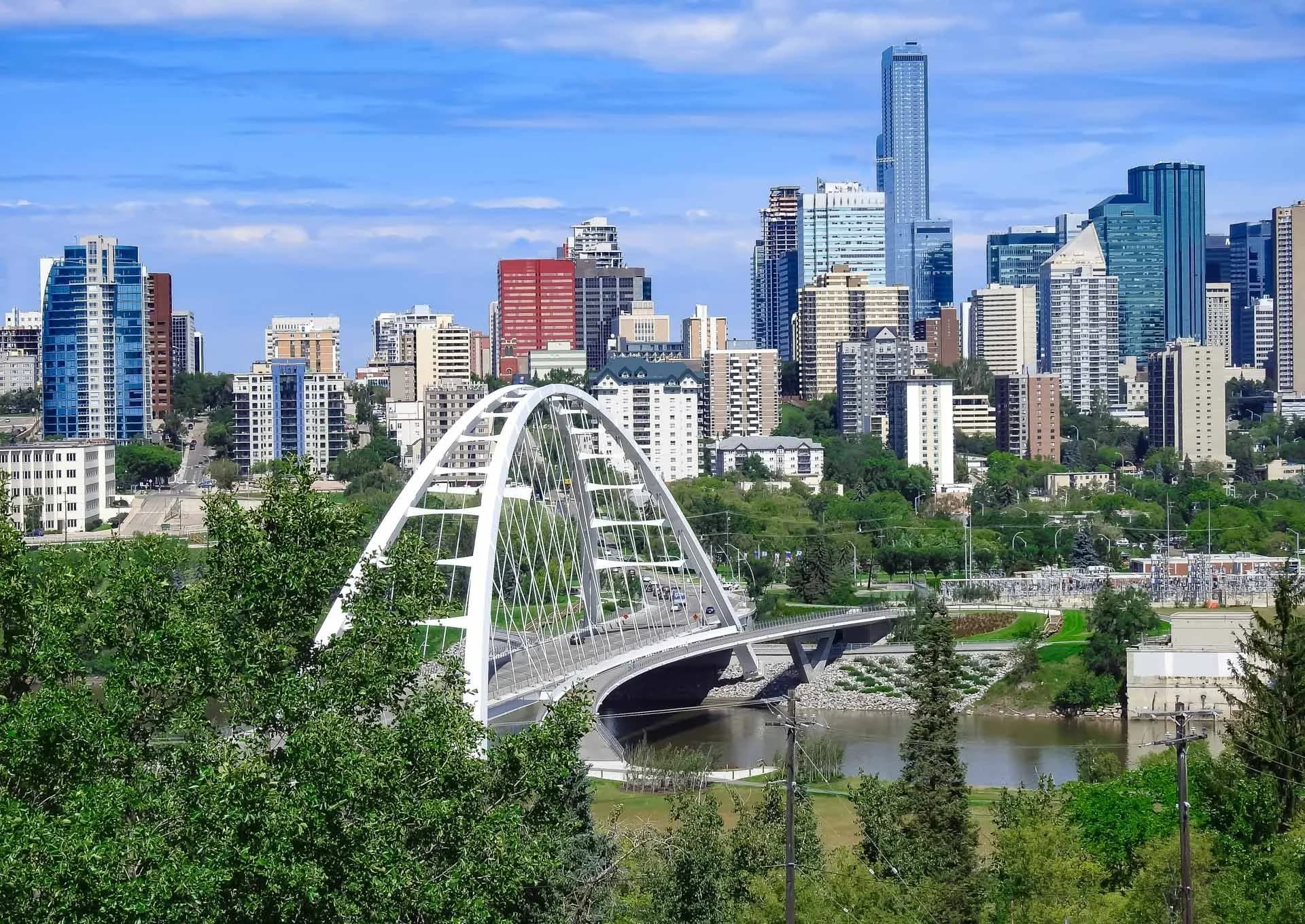 Downtown Edmonton streetscape with mature trees along a busy urban corridor